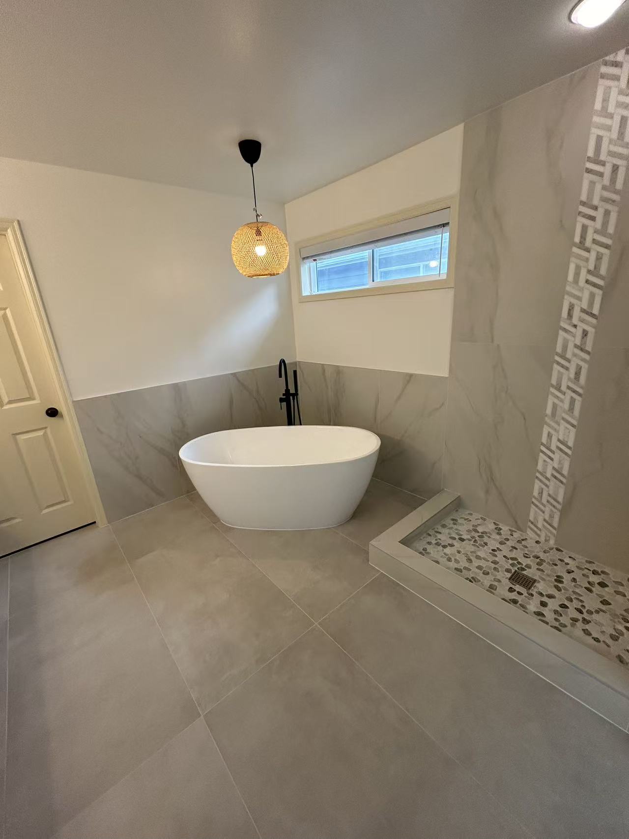 Bothell master bath renovation — after, freestanding soaker, marble walls, and woven pendant