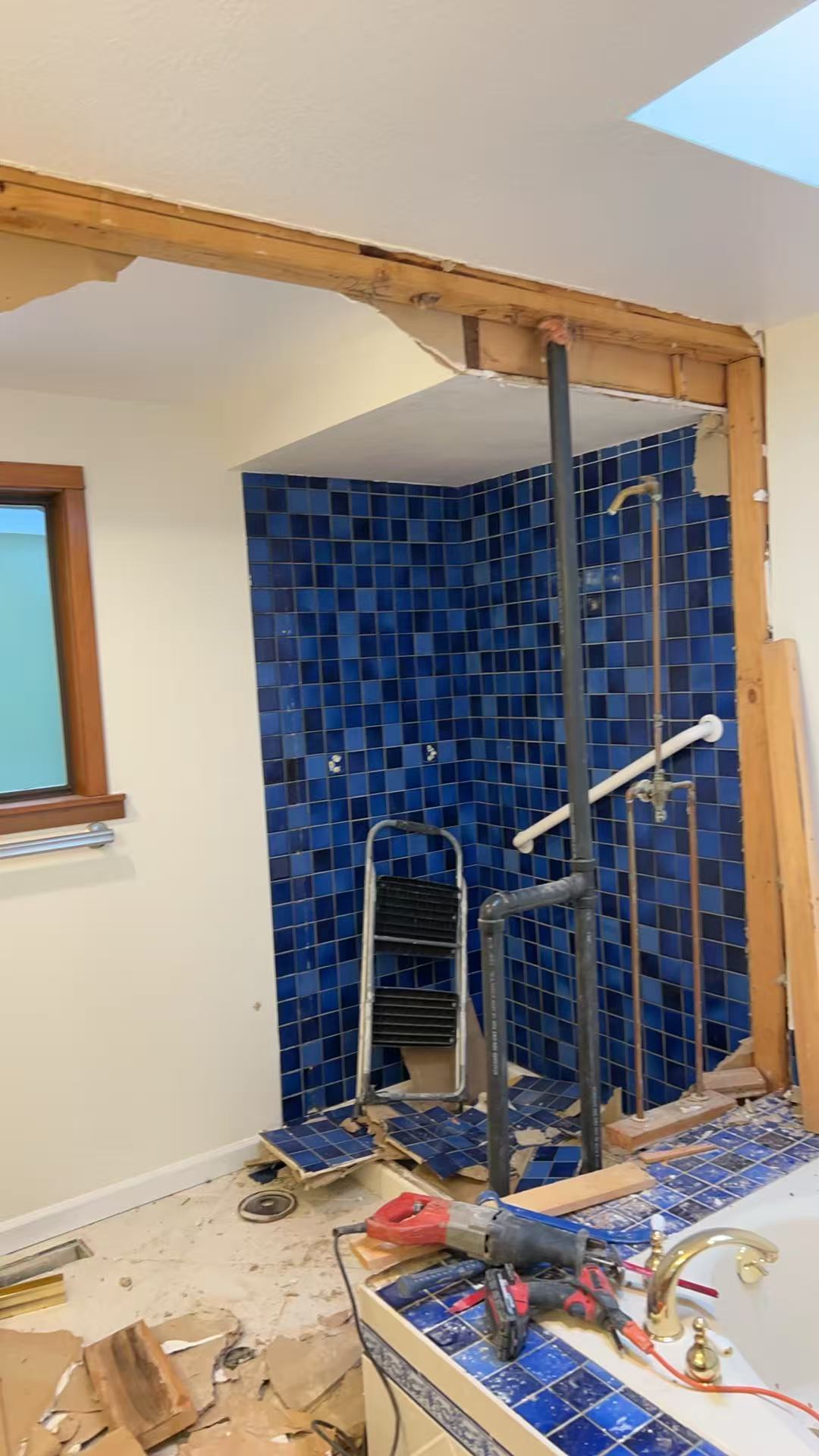 Bellevue spa bath renovation — before, bold blue mosaic shower with brass fixtures